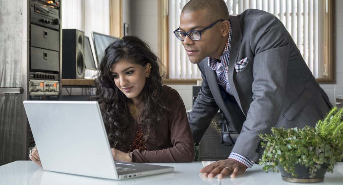 Ethnically diverse professionals working together on a computer in an office