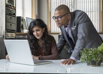 Ethnically diverse professionals working together on a computer in an office